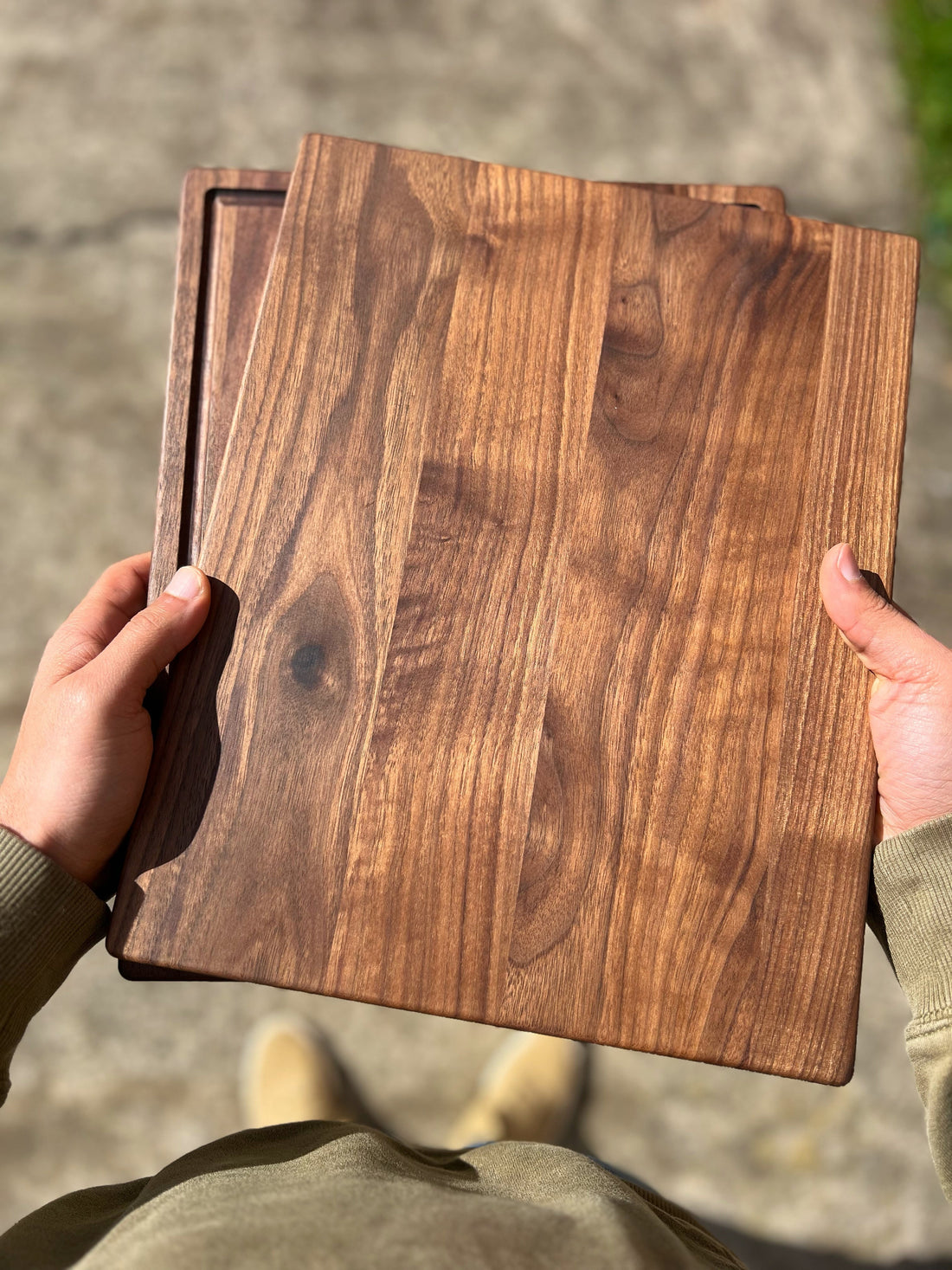 Black walnut cutting board with juice groove beside a hard maple board, ready for engraving