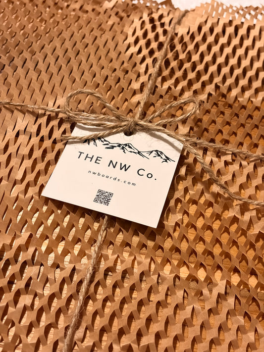 Cutting board wrapped in kraft paper with a hang tag, ready to give