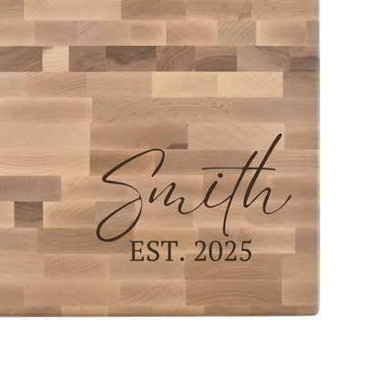 Hard maple end grain butcher block engraved with a family name in script and an EST. date