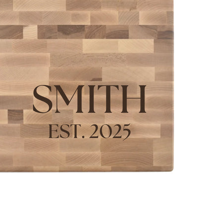 Hard maple end grain butcher block engraved with a family name and EST. date in serif lettering