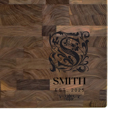 Black walnut end grain butcher block engraved with an ornate monogram initial, family name, and EST. date
