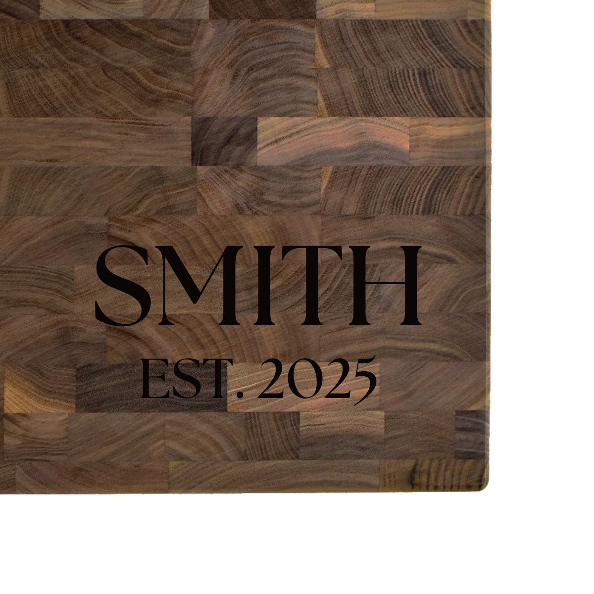 Black walnut end grain butcher block engraved with a family name and EST. date in serif lettering