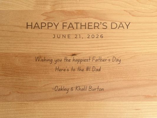 Back of a cutting board engraved with a note: a Happy Father's Day heading, the date, a two-line message, and a signature
