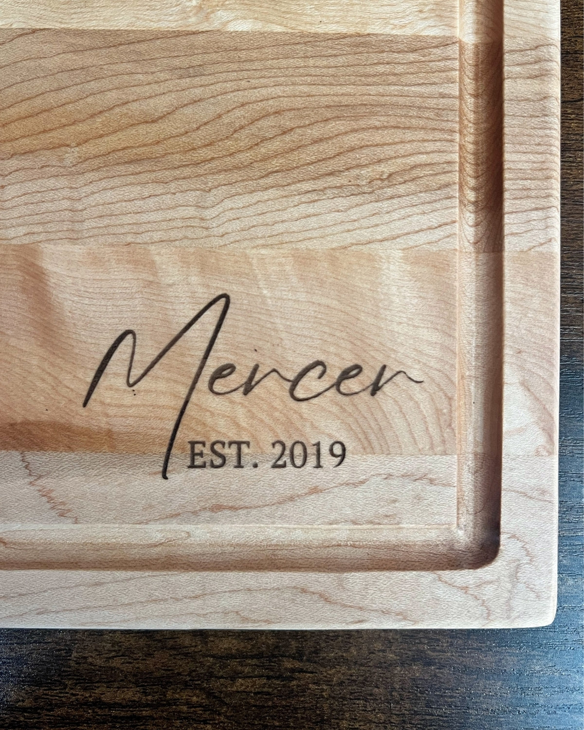 Hard maple cutting board with a juice groove, engraved Mercer EST. 2019 in script lettering