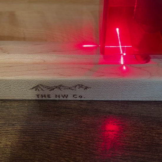Video of a hard maple cutting board being laser engraved with a personalized name