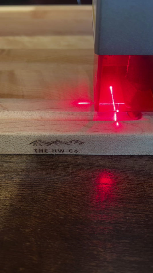 Video of a hard maple cutting board being laser engraved with a personalized name
