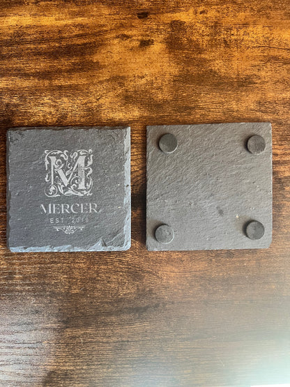 Underside of an engraved slate coaster showing the four cork feet that protect furniture