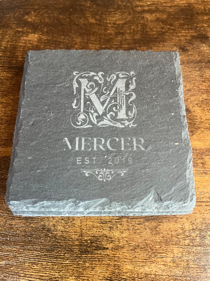 Personalized slate coaster engraved with an ornate framed M monogram above the Mercer family name
