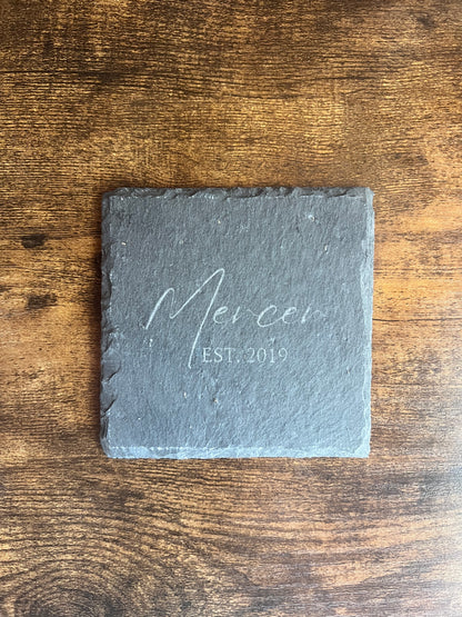 Personalized slate coaster engraved Mercer EST. 2019 in script lettering, shown from above